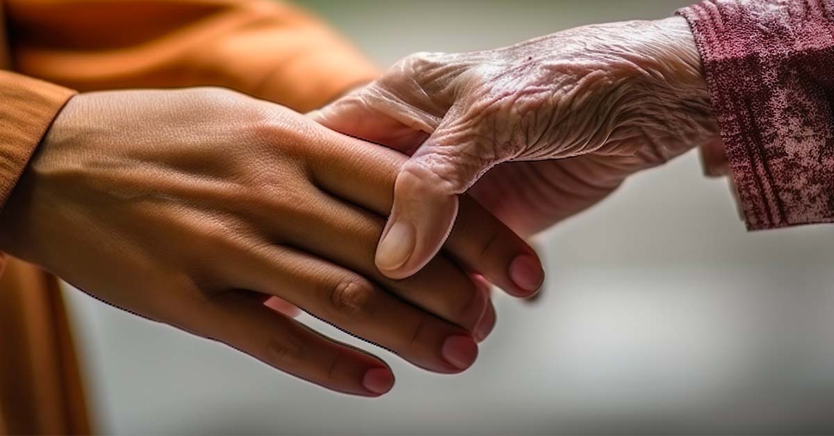 elderly hand grasping the first two fingers of a younger person's hand